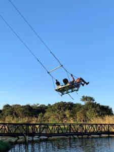 people on a zip line over a bridge over water at Stephen Margolis Resort in Harare