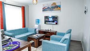a living room with two blue chairs and a table at Kelly homes in Naivasha in Naivasha