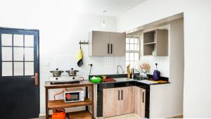 eine Küche mit weißen Schränken und einer schwarzen Arbeitsplatte in der Unterkunft Kelly homes in Naivasha in Naivasha