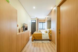 um quarto com uma cama com uma colcha amarela em Host Wise - Porto Urban Escape no Porto