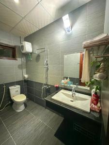 uma casa de banho com um lavatório, um WC e um espelho. em RUBY HOMESTAY em Hue