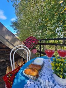 einem blauen Tisch mit einem Teller mit Speisen und Weingläsern in der Unterkunft Ethno village Montenegro Brezna in Plužine