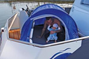 a man holding a child in a tent on a boat at Houseboat on the Peene in Demmin in Verchen