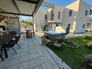 a patio with a table and a hot tub in a yard at Villa Balić - Podstrana in Podstrana