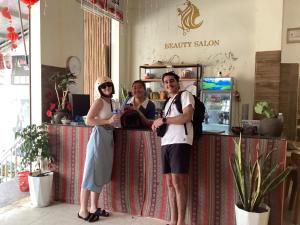 a group of three people standing at a counter at Du Gia View Homestay in Làng Cac