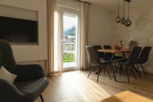 een woonkamer met een tafel en stoelen en een raam bij Ferienwohnung Schönblick in Weissenbach am Lech