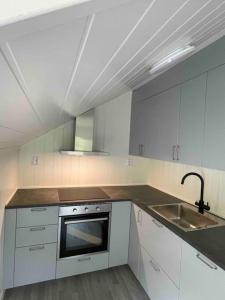 a white kitchen with a sink and a stove at New appartment in Lom inkl bedding in Lom