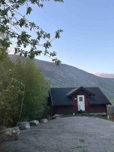 a red and white house with a mountain in the background at New appartment in Lom inkl bedding in Lom +13 photos