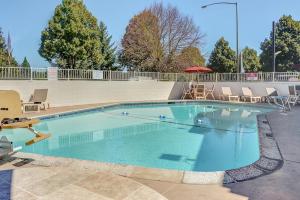 una gran piscina con sillas y sombrilla en Motel 6-Portland, OR - Central, en Portland