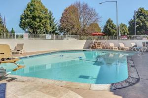 a large swimming pool with chairs and an umbrella at Motel 6-Portland, OR - Central in Portland