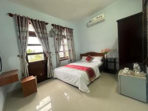 um quarto com uma cama e uma janela em RUBY HOMESTAY em Hue