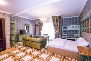 a bedroom with a bed and a couch and a chair at Aynur Qala Resort in Quba