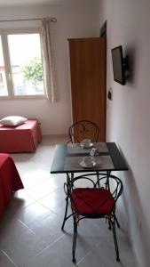 a table and chair in a room with a bedroom at Ca'Mea in Villasimius
