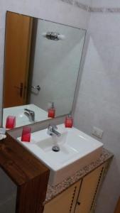 bagno con lavandino bianco e specchio di Ca'Mea a Villasimius