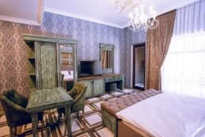 a bedroom with a bed and a chair and a television at Aynur Qala Resort in Quba