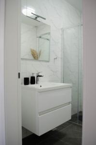 a white bathroom with a sink and a mirror at Kuća za odmor 'Luca' in Ljubuški