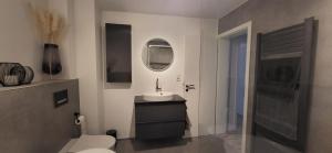 a bathroom with a sink and a toilet and a mirror at Gasthaus Sürder Hof in Grevenbroich +16 photos