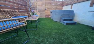 eine Terrasse mit Bänken, Grill und Gras in der Unterkunft Maison Plus Belle La Nuit avec jacuzzi privé in Allauch