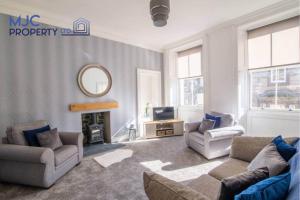 a living room with a couch and chairs and a mirror at The Old Bank in Hawick
