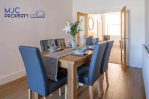 a dining room table with blue chairs around it at The Old Bank in Hawick