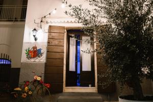 a door to a house with a tree in front at Apulia Suite in Castellana Grotte