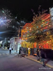 a street with a building with fireworks in the background at Bonita casa en el corazón de la feria in Aguascalientes