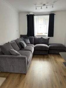 un soggiorno con divano grigio di fronte a una finestra di A Luxurious 3 Bed-Terrance House a Londra