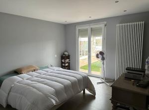 a white bedroom with a large bed and a window at Villa avec piscine au cœur de la ville in Tournon-sur-Rhône