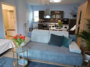 un soggiorno con un divano blu e una cucina di Apart Charmant Köthen a Köthen