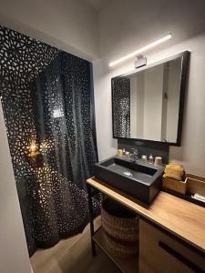 聖丹尼斯的住宿－Ty Cosy - T2 proche du centre de St-Denis，浴室设有黑色水槽和浴帘