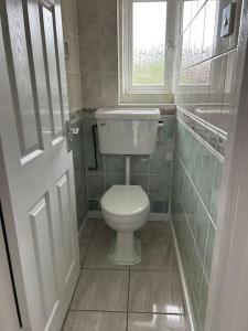 baño pequeño con aseo y ventana en A Luxurious 3 Bed-Terrance House en Londres