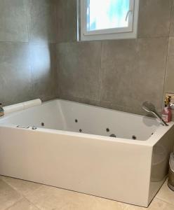 a white bath tub in a bathroom with a window at Villa avec piscine au cœur de la ville in Tournon-sur-Rhône