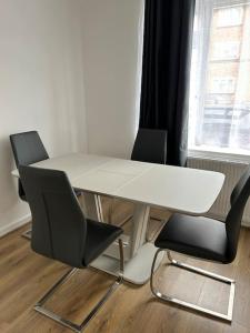 een witte tafel en twee stoelen voor een raam bij A Luxurious 3 Bed-Terrance House in Londen