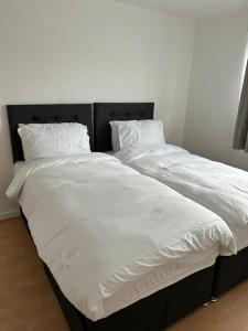2 camas individuales con sábanas y almohadas blancas en A Luxurious 3 Bed-Terrance House en Londres