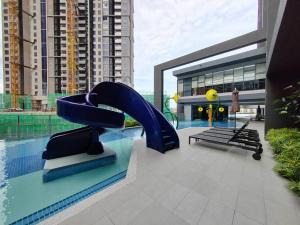 een zwembad met een blauwe glijbaan in een gebouw bij Sunway Velocity 2 # 2BR (Link to Mall) in Kuala Lumpur