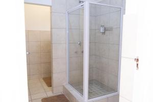 a shower with a glass door in a bathroom at George Lodge International in George