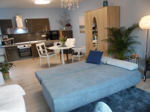 un soggiorno con un divano blu e una cucina di Apart Charmant Köthen a Köthen