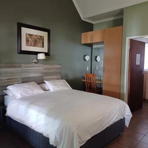 Postel nebo postele na pokoji v ubytování Rustenburg Palm Lodge