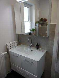 a bathroom with a white sink and a mirror at Apart Charmant Köthen in Köthen