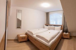 een slaapkamer met een groot bed en een raam bij Ferienwohnung Schönblick in Weissenbach am Lech