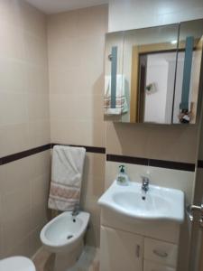 a bathroom with a sink and a toilet and a mirror at Jardines del Mar in Oropesa del Mar