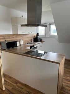 a kitchen with a counter with a sink and a microwave at Ferienvermietung Schneider in Wiehl