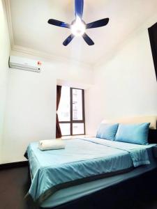a bedroom with a blue bed with a ceiling fan at Sofia Superior Suite 2R2B-51902 at R&F Princess Cove in Johor Bahru