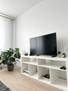 a white entertainment center with a flat screen tv on it at Modernūs apartamentai Šilutėje in Šilutė