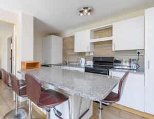 uma cozinha com armários brancos e um balcão de granito em San Lameer Villa 10417 - 1 Bedroom Classic - 2 pax - San Lameer Rental Agency em Southbroom