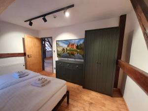 1 dormitorio con 1 cama y TV de pantalla plana en Residence Stálkov Česká Kanada, en Slavonice