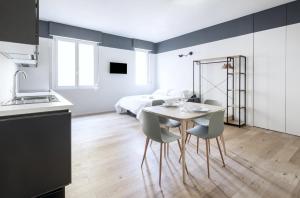 ミラノにあるEasylife - Stupendo Monolocale zona Risorgimentoのテーブルと椅子のあるキッチンとダイニングルーム