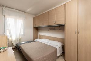 a bedroom with a bed and cabinets and a window at Residence Uno Studio&Suites in Rimini