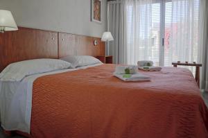 a large bed with two towels and two candles on it at Nuna Ayni Apartments in Alta Gracia