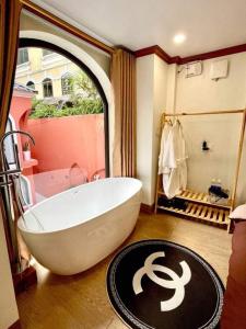ein Bad mit einer großen weißen Badewanne in einem Zimmer in der Unterkunft L’abri Retreat _ Venuestay in Tam Ðảo